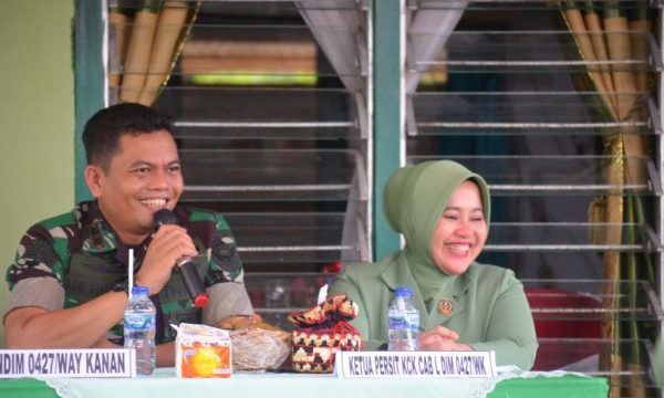 a man and woman sitting at a table with a microphone